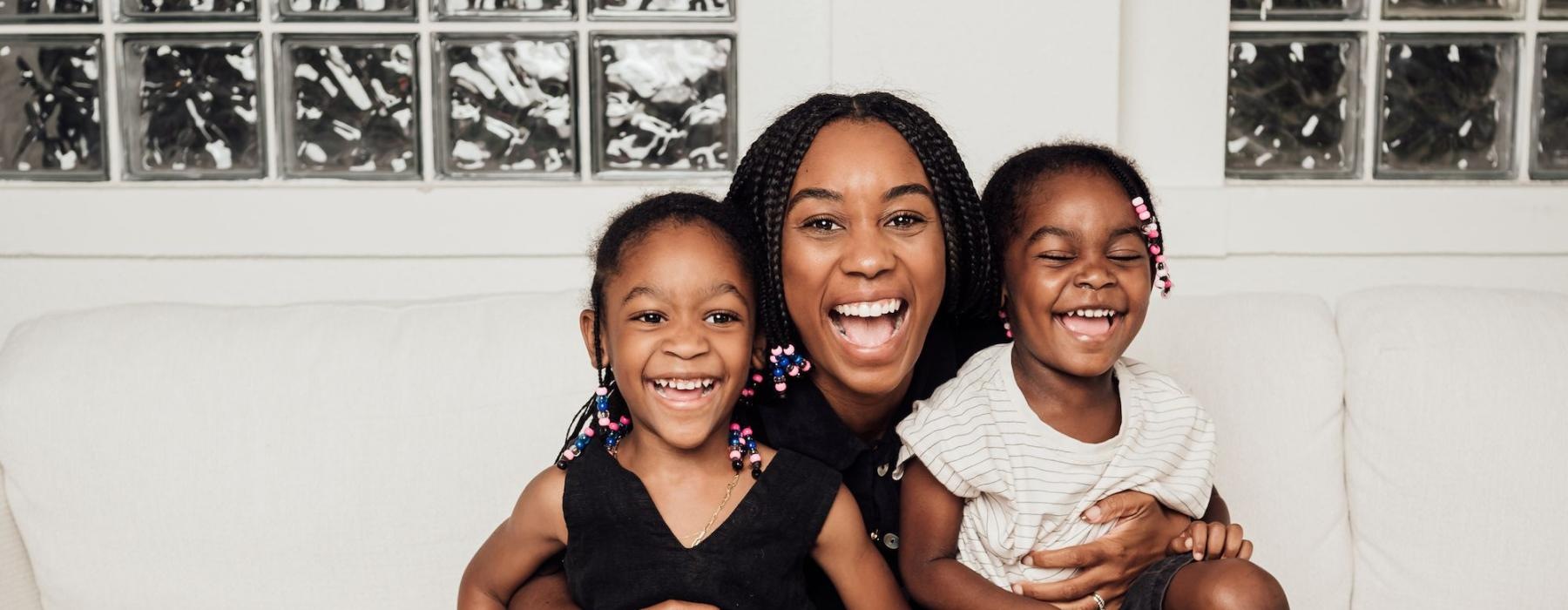 a woman sitting on a couch with two kids
