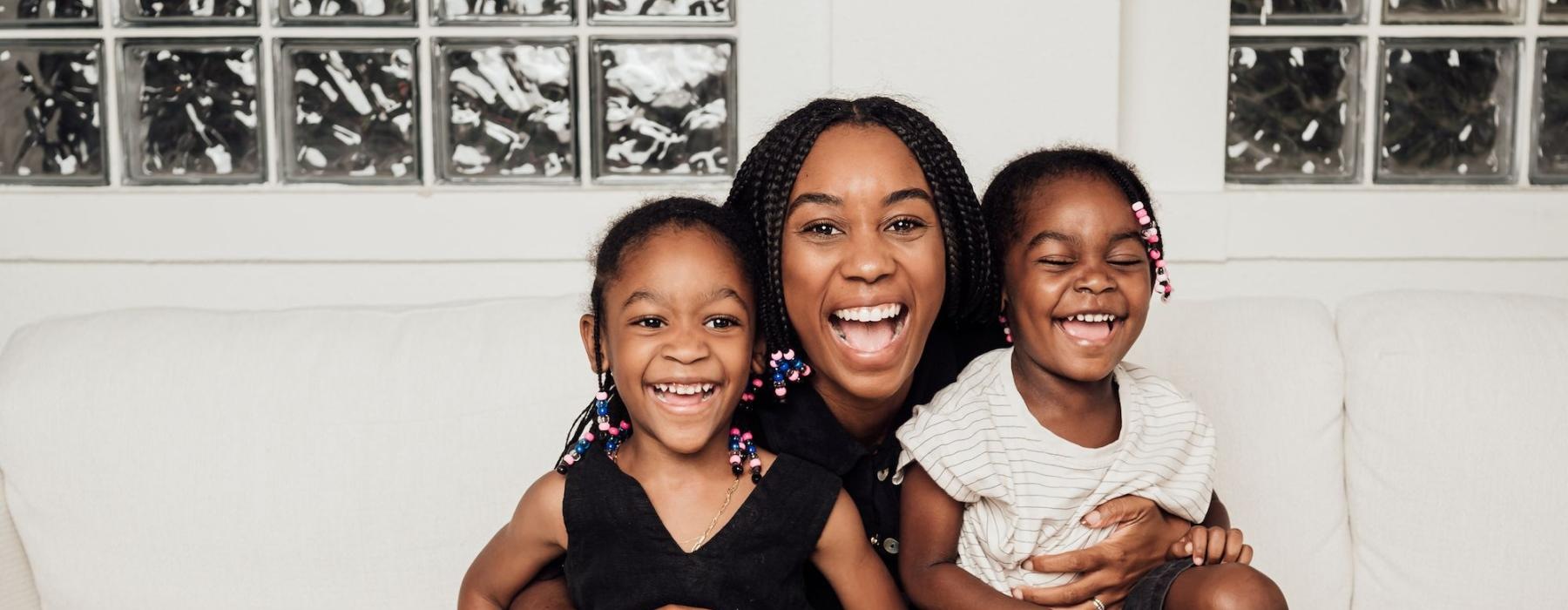a woman sitting on a couch with two kids